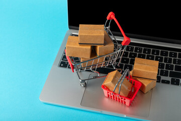 Online shopping concept.Cardboard box and shopping bags in a trolley on a bright colored...