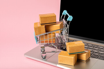Online shopping concept.Cardboard box and shopping bags in a trolley on a bright colored...