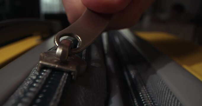 Packing bags journey, adventure and fascinating exploration. Vacation dreams, preparation for travel.Zipper on suitcase. Zipping closing yellow travel luggage. Unrecognizable fingers pull zipper tab.
