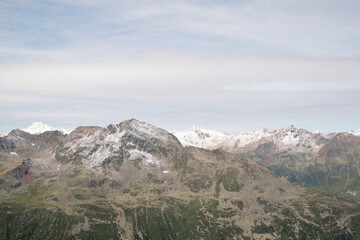 Curvy hairpins of Timmelsjoch road with green rolling hills background