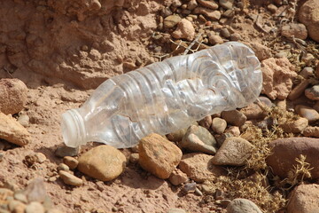 A single empty plastic bottle lying on the ground, Environmental pollution
