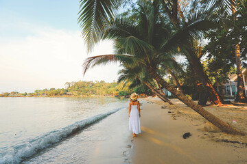 Asian woman relaxing walking on beach during her travel  vacation in Thailand