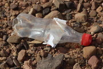 A single empty plastic bottle lying on the ground, Environmental pollution