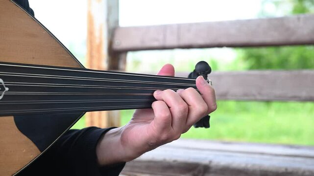 Man playing oud, a traditional musical instrument in Turkey, close-up.