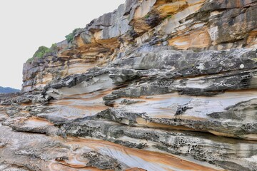 Layered coastal rock formations with unique erosion textures and natural patterns. Perfect for geology, backgrounds, and nature-related content.