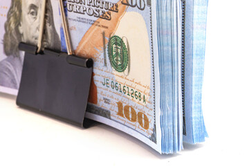 Dollar bill money clip. stack of hundred dollar bills held together by a black binder clip