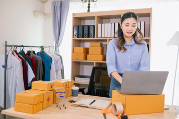 Asian woman starts a small SME business using her home as Home Office and checks inventory to...