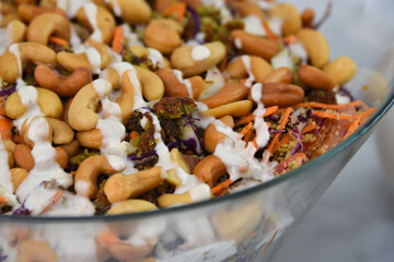 Vibrant Broccoli Cashew Salad in glass bowl creamy sauce features broccoli florets, crunchy cashews, shredded carrots, and red cabbage closeup closeup top view of healthy salad