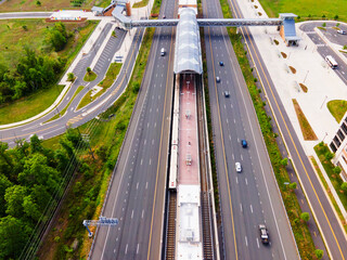 Above-ground subway station in Washington suburbs. Highways, parks and bus stops. Drone view.