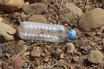 A single empty plastic bottle lying on the ground, Environmental pollution