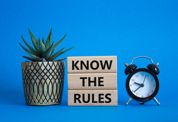Know the rules symbol. Wooden blocks with words Know the rules. Beautiful blue background with...