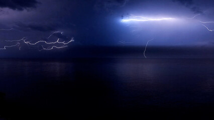 Lightening Storm Cloud-to-air lightning large bolts streaking across the night sky in a dramatic storm over the ocean