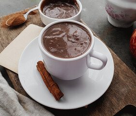 white porcelain cup with hot, creamy chocolate and dark background