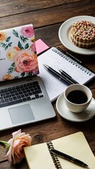 Writer workplace with laptop, coffee, cake and notebooks on wooden table