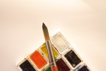 Artistic Paintbrush Resting on a Colorful Watercolor Palette with Bright Lighting
