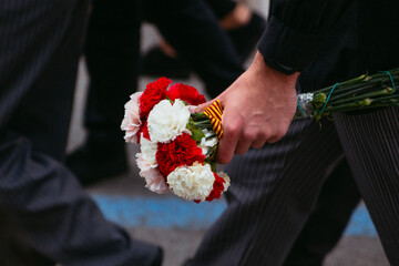 Lagrimas de Santa Marta in La Vila Joiosa. Man carrying Santa Marta bouquet of red and white...