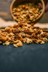 Close-up of granola and almond on a rustic textile surface. Macro view highlighting texture and detail of healthy breakfast ingredients with natural warm tones