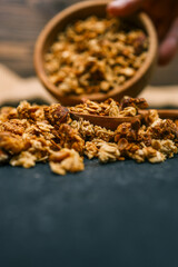 Close-up of granola and almond on a rustic textile surface. Macro view highlighting texture and detail of healthy breakfast ingredients with natural warm tones