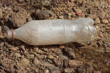 A single empty plastic bottle lying on the ground, Environmental pollution