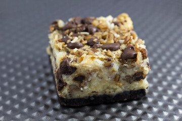 Irresistible dessert bars featuring a rich coconut base topped with chocolate chips and nuts, ideal for tempting sweet cravings and perfect for dessert photography.