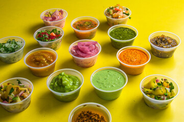 An artistic arrangement of vibrant sauces in small bowls on a yellow tablecloth, each representing a unique blend of flavors perfect for enhancing culinary experiences.