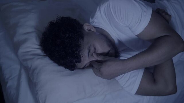 Man struggling with sleep and insomnia in bed