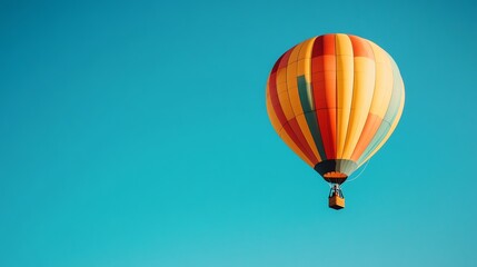 Naklejka premium A brightly colored hot air balloon floats serenely against a vibrant, clear blue sky.