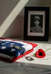 Memorial Day tribute with folded American flag, soldier portrait, dog tags and poppy flower on marble – honoring fallen heroes 