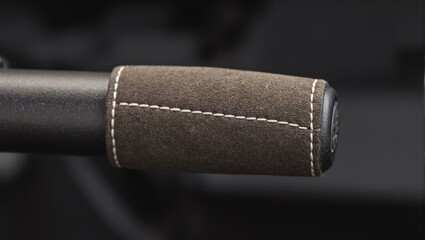 Luxurious suede wrapped parking brake handle with exquisite stitching detail in a high performance car interior