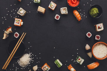 Sushi and rolls background, frame on black, top view. Colorful japanese restaurant food set