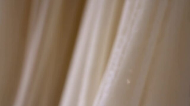 Elegant light cream fabrics with a subtle floral pattern cascade creating a soft, flowing and textured background for delicate designs and ethereal compositions.