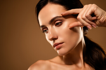 Portrait of a young tempting woman with flawless skin and natural beauty on a beige background