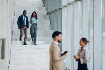 Business people walking down stairs in modern office building