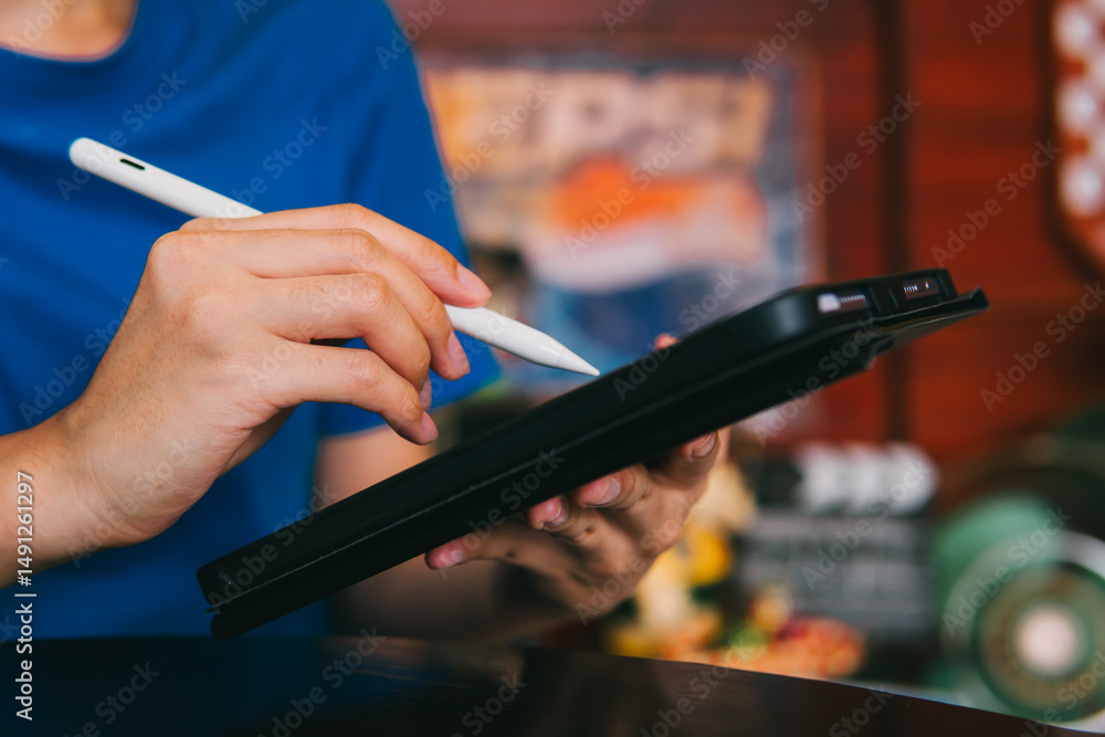Poster person using digital stylus on tablet device for creative work with colorful background in cafe sett