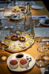 Champagne tasting, Wine glasses are on the table, stylish table setting, sparkling wine bubbles, oysters and sea urchins, special sauce