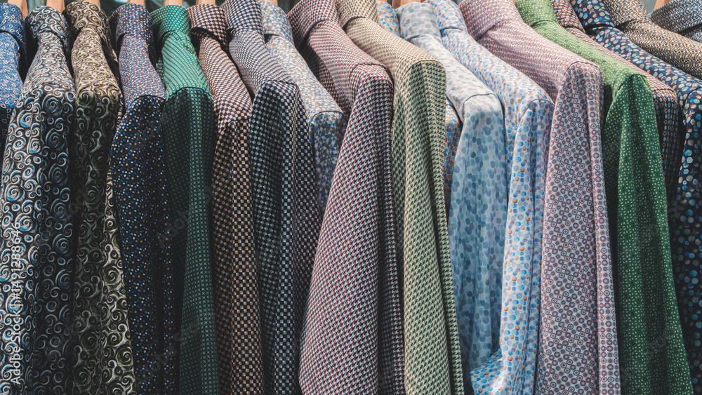 Aufkleber a row of clothes with different patterns and colors. the clothes are hanging on a rack.