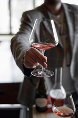 Champagne tasting in restaurant, A man holds in his hand a beautiful elegant glass with rose sparkling wine
