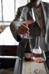 Champagne tasting in restaurant, A man holds in his hand a beautiful elegant glass with rose sparkling wine
