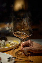 Champagne tasting, Wine glasses are on the table, stylish table setting, wine is poured from a bottle and decanter, sparkling wine bubbles, snacks, people smell the aroma and taste the wine