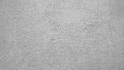 Obraz premium A grey concrete wall with a few small cracks. The wall is very plain and unadorned abstract texture background for template pages and banners