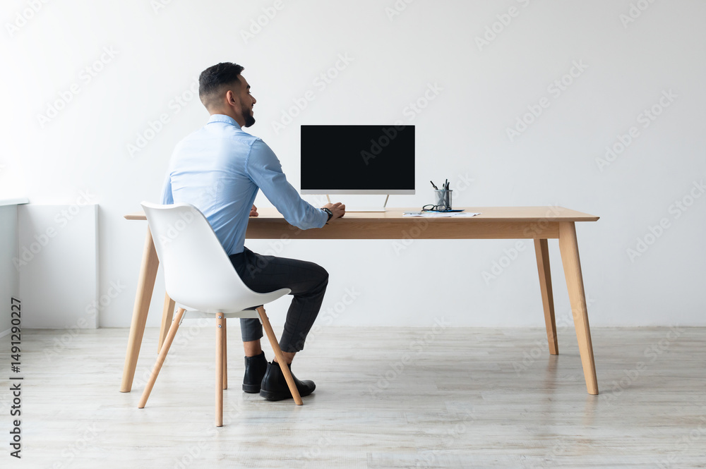 Aufkleber rear back view portrait of middle eastern businessman looking at blank empty computer monitor sittin