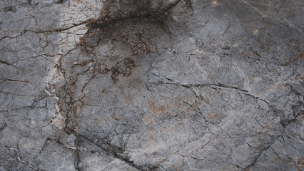 A grey stone wall with a few cracks and holes. wall is rough and uneven, giving it a rugged appearance, abstract texture background for template pages and banners