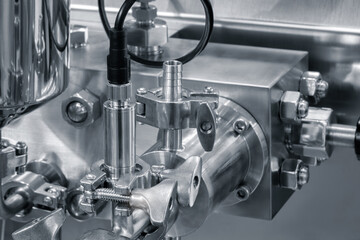 A machine with a silver casing and a black cable. The cable is attached to a device that is connected to a computer