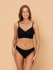 Fototapeta premium Girl model in underwear posing in studio on beige background.