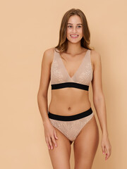 Fototapeta premium Girl model in underwear posing in studio on beige background.