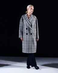 Girl model posing on black background in studio, stylish clothes, fashion photography.