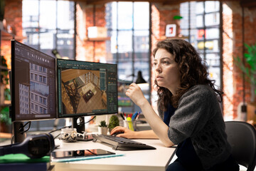 Worker in a creative office uses CAD software to design a house interior, provides a user interface...