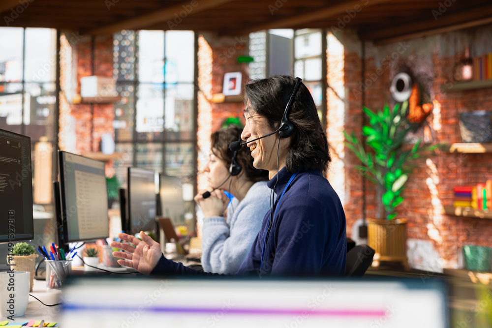 Poster call center agent laughing while talking with funny customer using headset mic while providing guida