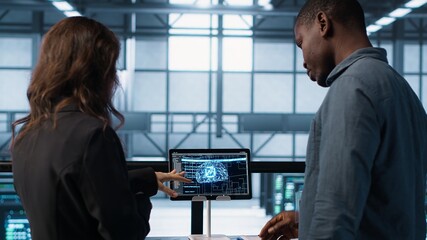 Data center team reviewing paperwork in server room, analyzing system reports using AI on tablet. Artificial intelligence server room admins looking over financial documents, camera A