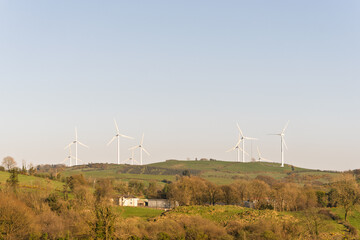 A group of wind turbines are on a hillside